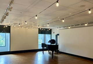 a room with a piano and fairy lights